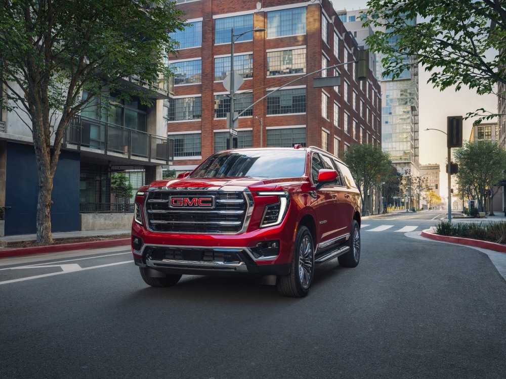 Red GMC Yukon in driving in urban setting