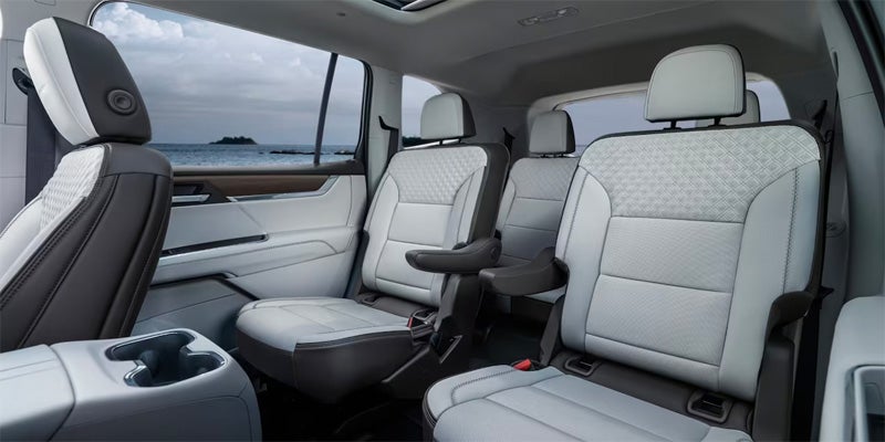 view of the second and third row rear passenger seats that are white leather inside of a 2024 GMC Acadia